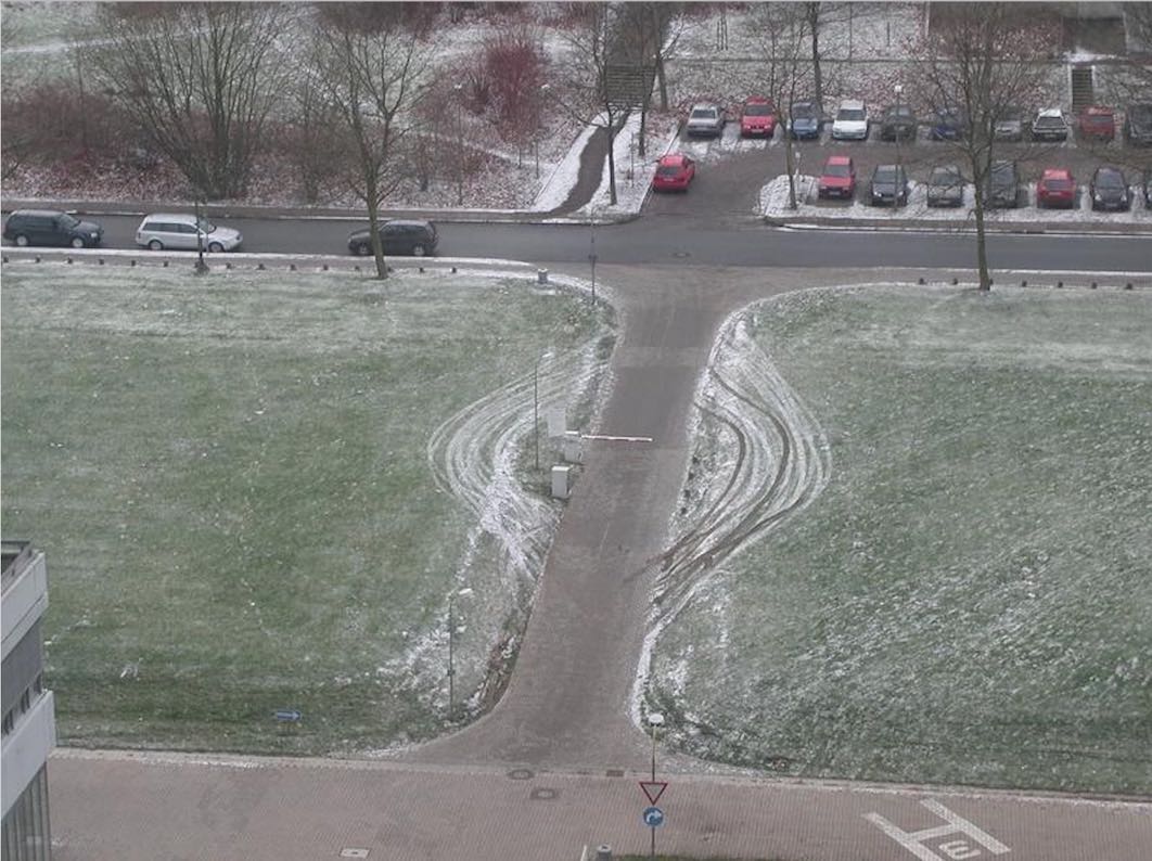 Car park security barrier in context with tyre marks going around barries on both sides